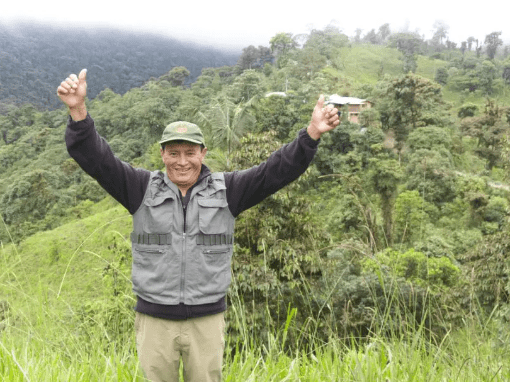 Angel Paz stands before his family's land, celebrating his success as an eco-tourism entrepreneur.